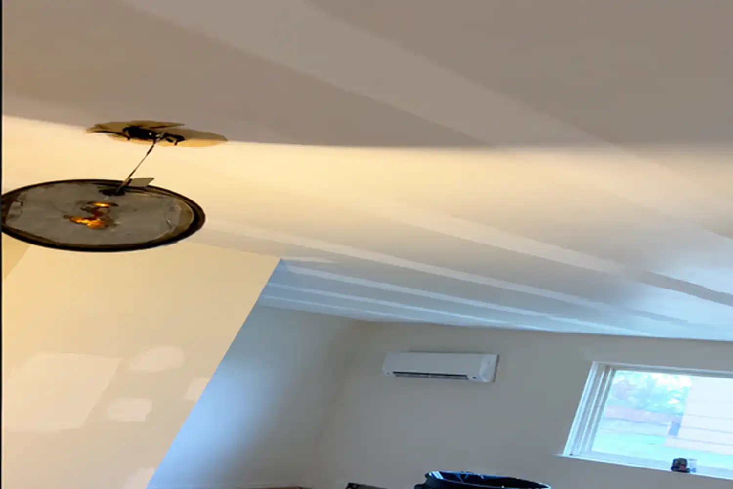 Sagging drywall ceiling section hanging lower than the surrounding ceiling